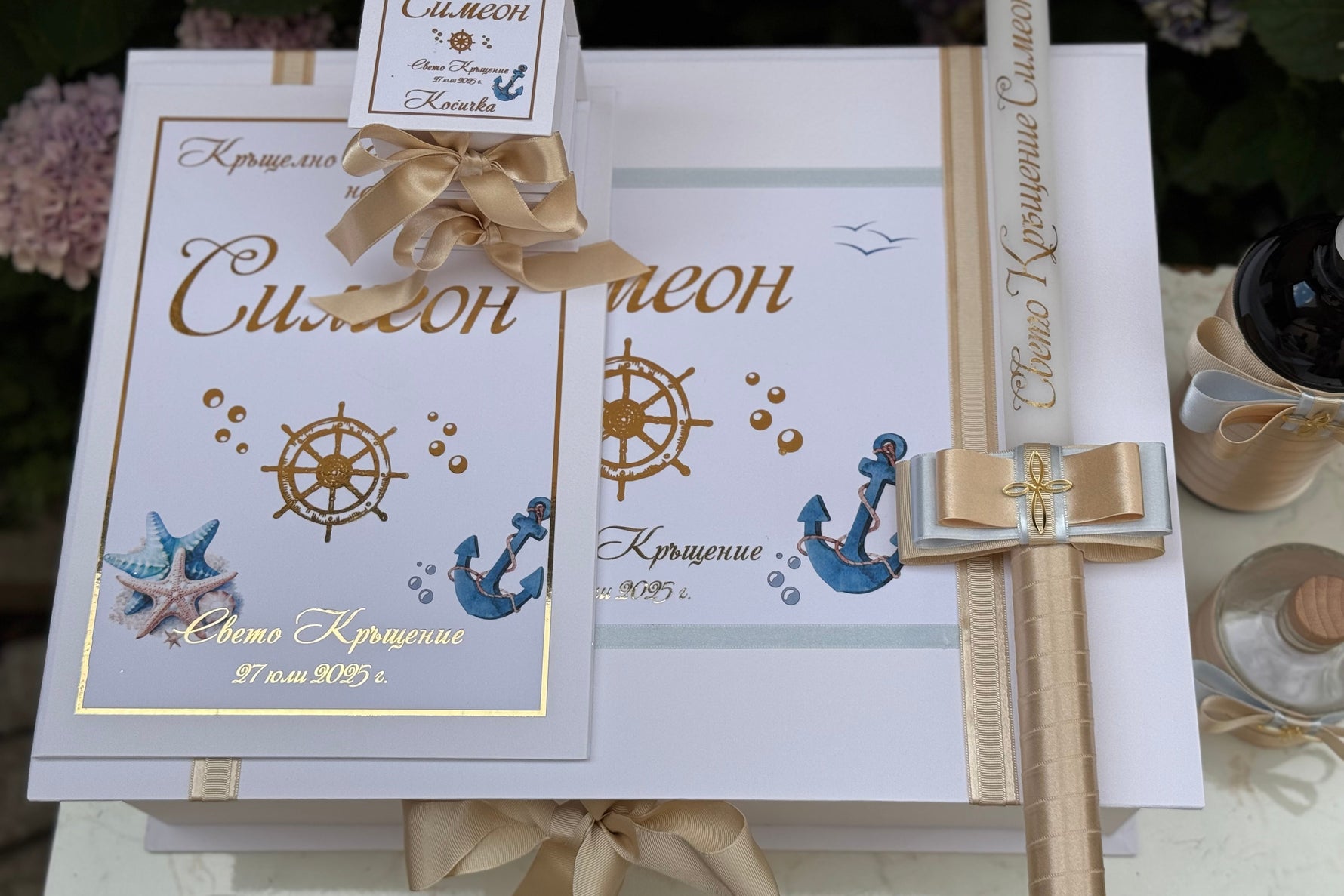 Christening Box with anchor and starfish designs, gold text and ribbon, and candle on a white background.