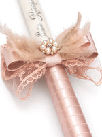 Decorative candle with pink lace bow and pearl embellishments on a light background