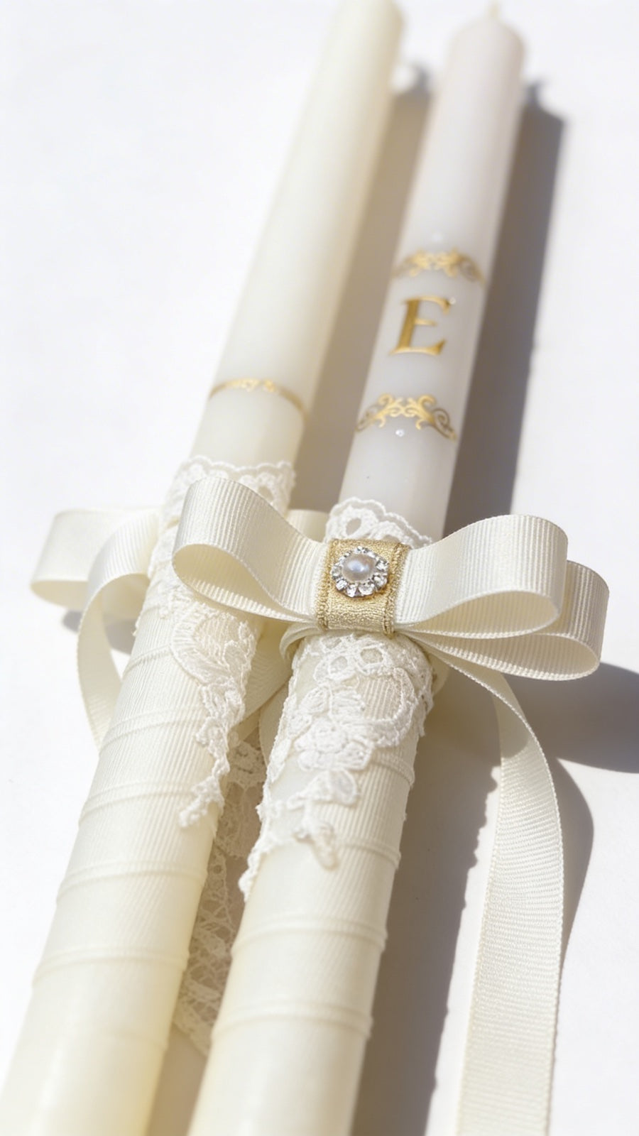 Wedding candles with decorative ribbons and lace, with gold initials and elements.
