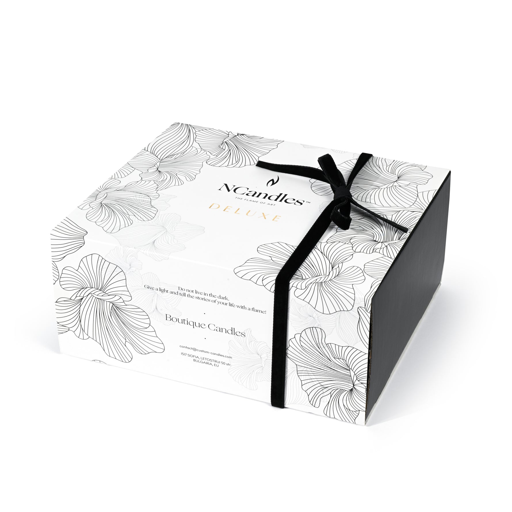 Candle box with floral design and black ribbon on a white background