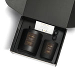Two black candles in a box with a card and scissors, featuring the brand 'NCandle'.