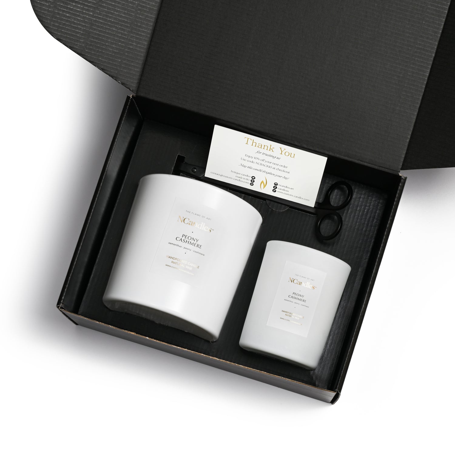 black box with 2 sized candles in white matt vessels 